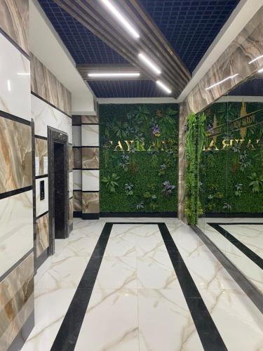 a lobby with a green wall with plants at Апартаменты Юнусабад 14, в новостройке Хон Сарой Сайрам in Magaldarkhan