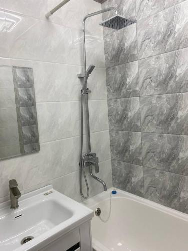 a bathroom with a shower and a tub and a sink at Апартаменты Юнусабад 14, в новостройке Хон Сарой Сайрам in Magaldarkhan