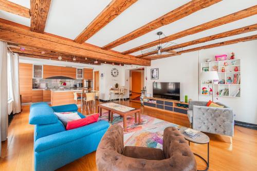 un salon avec un canapé bleu et des chaises dans l'établissement La Place de la Cathédrale - Superbe appt face à la Cathédrale, à Strasbourg