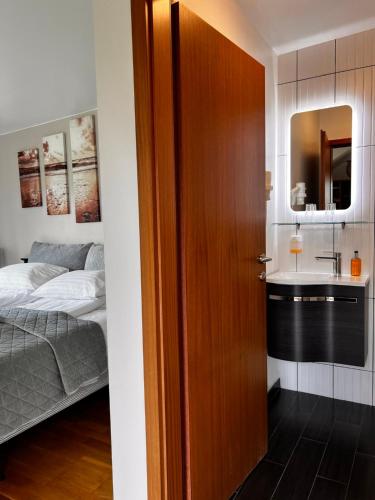 eine Tür, die zu einem Schlafzimmer mit einem Waschbecken führt in der Unterkunft Hotel Skógá by EJ Hotels in Skógar
