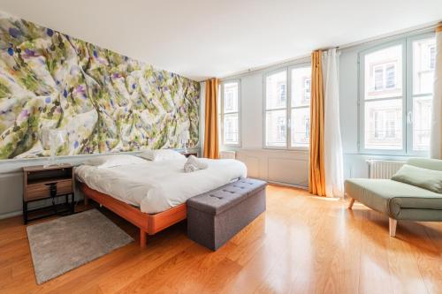 une chambre avec un lit et un tableau au mur dans l'établissement La Place de la Cathédrale - Superbe appt face à la Cathédrale, à Strasbourg