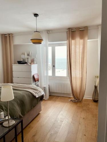 une chambre avec un lit et une grande fenêtre dans l'établissement Les Voiles Baie de Quiberon - Villa, à Plouharnel