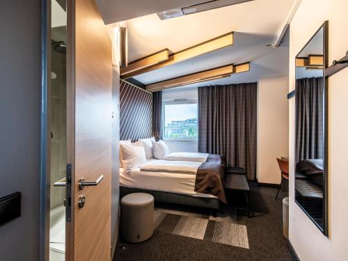 um quarto de hotel com uma cama e uma janela em B&B HOTEL München-Messe em Aschheim