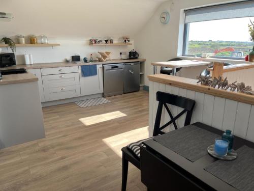 a kitchen with a counter and a table in a room at Island View Apartment in Miltown Malbay