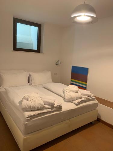 a bedroom with a bed with towels on it at Wellness Smart Suites in Bolzano