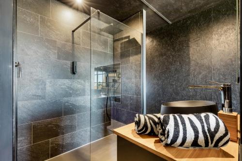 une salle de bain avec une douche en verre et un lavabo dans l'établissement L'écrin noir Port nature, au Cap d'Agde