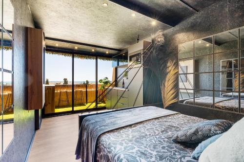 une chambre avec un grand lit et un balcon dans l'établissement L'écrin noir Port nature, au Cap d'Agde