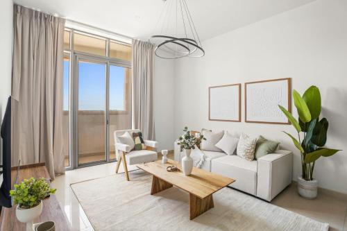 a living room with a white couch and a table at Silkhaus Vacation Homes Chic 2BDR Near Reem Mall in Abu Dhabi