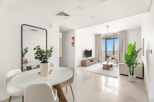 a white living room with a white table and chairs at Silkhaus Vacation Homes Chic 2BDR Near Reem Mall in Abu Dhabi