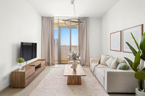 a living room with a couch and a tv at Silkhaus Vacation Homes Chic 2BDR Near Reem Mall in Abu Dhabi