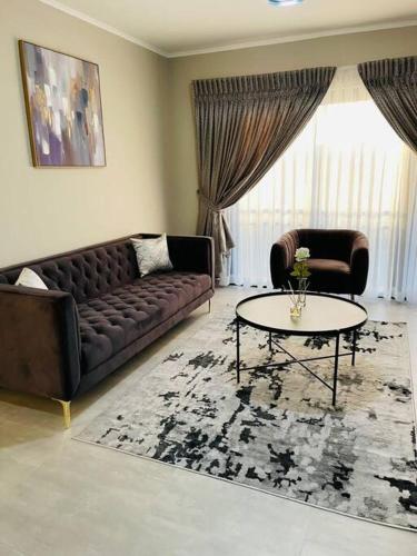 sala de estar con sofá y mesa en Motswedi 1 bedroom apartment B9, en Gaborone