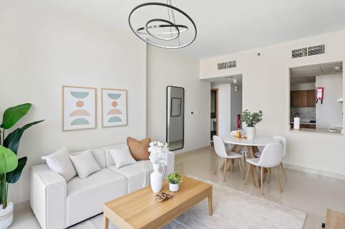 a living room with a white couch and a table at Silkhaus Vacation Homes Chic 2 BDR Near Reem Central Park in Abu Dhabi