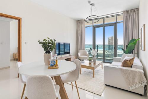 a living room with a white table and chairs at Silkhaus Vacation Homes Chic 2 BDR Near Reem Central Park in Abu Dhabi