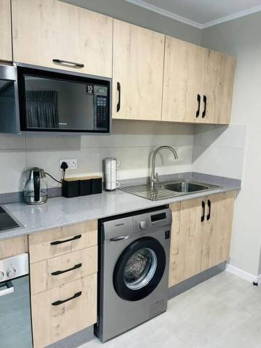 cocina con lavadora y fregadero en Motswedi 1 bedroom apartment B9, en Gaborone