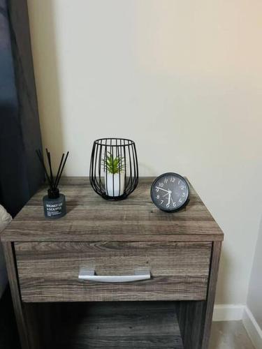 una mesa de madera con un reloj encima en Motswedi 1 bedroom apartment B9, en Gaborone