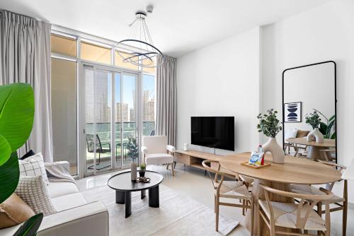 a living room with a table and a tv at Silkhaus Vacation Homes Convenient 1BDR Near Reem Mall in Abu Dhabi