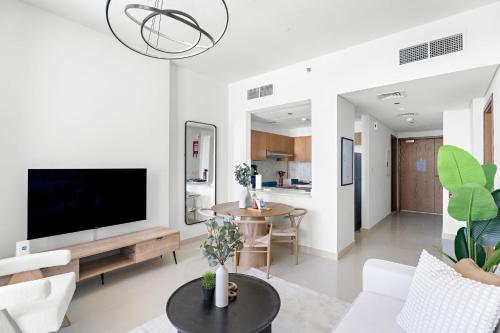 a living room with a television and a table at Silkhaus Vacation Homes Convenient 1BDR Near Reem Mall in Abu Dhabi