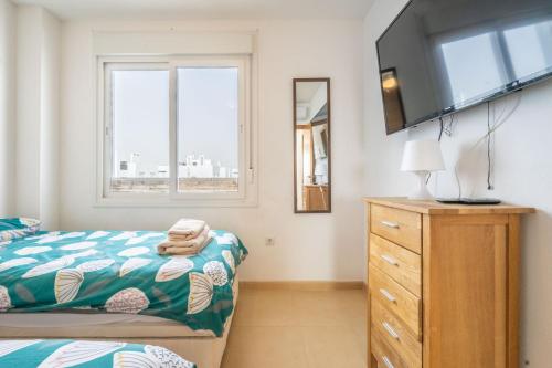 ムルシアにあるLovely penthouse apartmentのベッドルーム(ベッド1台、ドレッサー内のテレビ付)