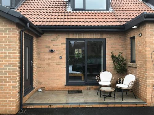 two chairs and a table on a patio at THE STUDIO - CHESTERFIELD - PEAK DISTRICT - EV point - Chatsworth in Chesterfield