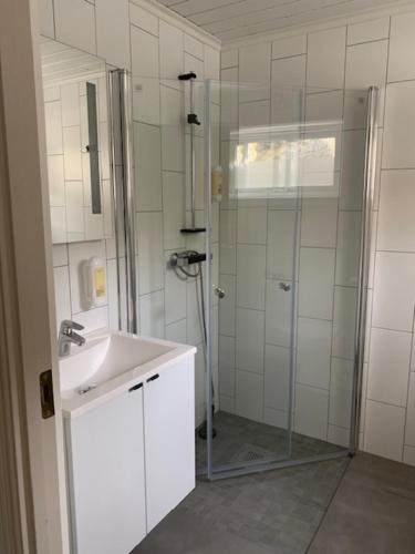 a bathroom with a glass shower and a sink at Trysnes Brygge in Kristiansand