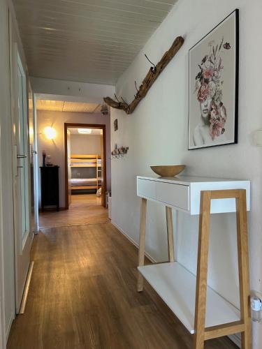 a hallway with a white table and a wooden floor at Ferienwohnung Casa de Mane&Tina mit Gartenmitbenutzung in Traunreut