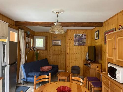 a living room with a blue couch and a table at Maison d'hôtes à la campagne in Labastide-dʼArmagnac
