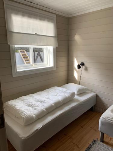 a bed in a room with a window at Trysnes Brygge in Kristiansand