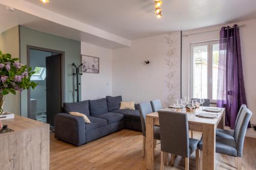 un salon avec une table et un canapé bleu dans l'établissement Esthense - 500m de la plage proche Baie de Somme, à Mers-les-Bains