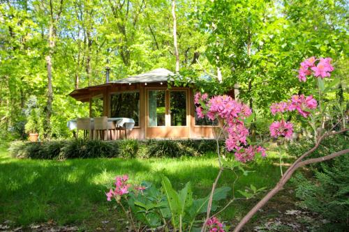 a gazebo in a garden with pink flowers at Woeste Hoogte - Groesbeek in Groesbeek