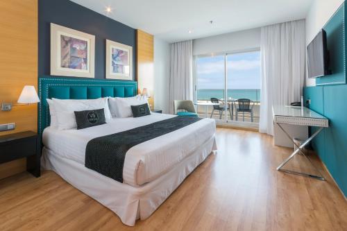 1 dormitorio con 1 cama grande y vistas al océano en VS Gandía Palace Hotel ****, en Gandía