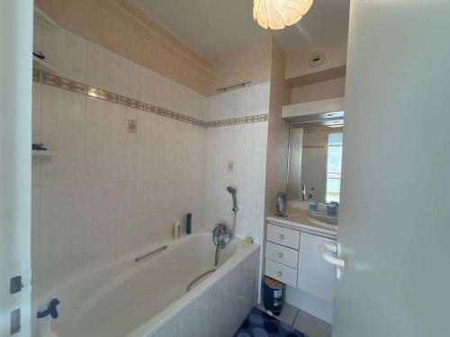 a bathroom with a bath tub and a sink at Appartement Royan, 2 pièces, 2 personnes - FR-1-494-98 in Royan