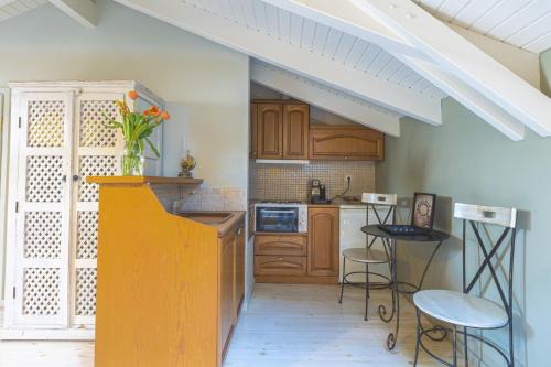 a kitchen with wooden cabinets and a vase of flowers at Arethousa Hotel in Katakolon