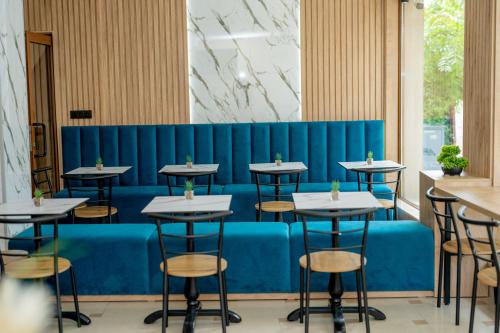 a row of tables in a restaurant with a blue bench at Lucky Hotel in Veliko Tŭrnovo