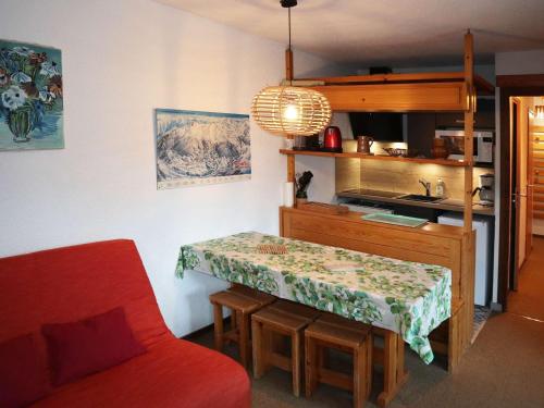 une petite cuisine avec une table et un canapé rouge dans l'établissement Appartement pour 6 personnes aux Orres, accès direct aux pistes - FR-1-322-543, aux Orres