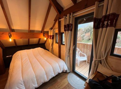 a bedroom with a bed and a large window at La Barque in Thollon