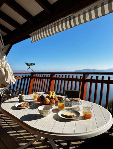 une table avec de la nourriture et des boissons sur un balcon dans l'établissement La Barque, à Thollon-les-Mémises