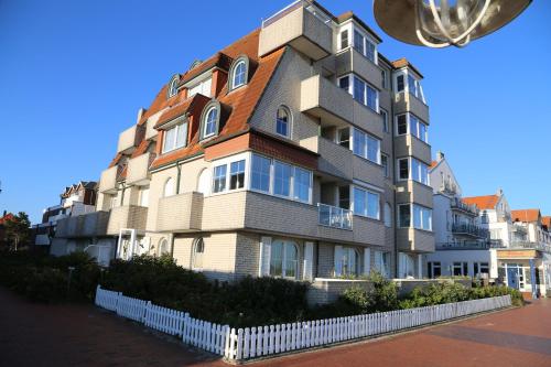 a tall building with a white fence in front of it at Strandvilla Marina 28 - Traumblick in Wangerooge