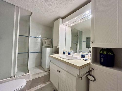 ein weißes Bad mit einem Waschbecken und einer Dusche in der Unterkunft Appartement Sainte-Maxime, 2 pièces, 4 personnes - FR-1-226-541 in Sainte-Maxime