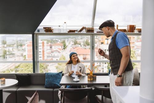 un homme et une femme assis à une table dans un restaurant dans l'établissement Aksjemøllen - by Classic Norway Hotels, à Lillehammer