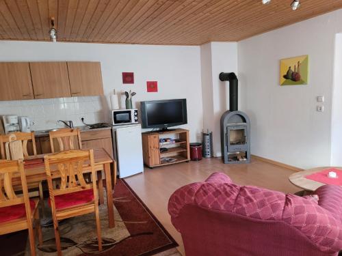 a living room with a couch and a table and a kitchen at Ferienwohnung 500m zum See in Vollrathsruhe