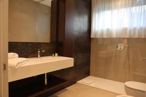 a bathroom with a sink and a shower at Midum LuxuryApartments con giardino in Trento