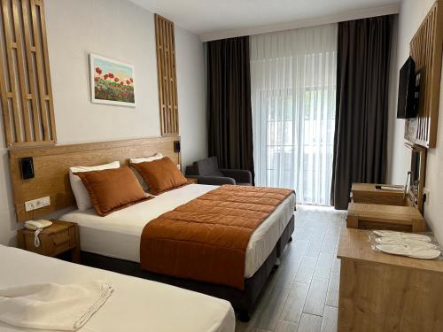 a hotel room with two beds and a television at Hotel Panaya in Gokceada Town