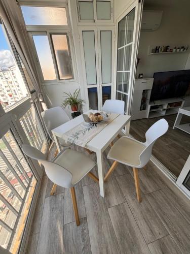 a dining room with a white table and chairs at Lucia Guest House Beach - apartamento Family, Friends & Fun PET FRIENDLY in Málaga