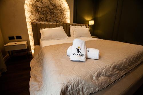 a hotel room with a bed with towels on it at Vila Koja Boutique Hotel in Tirana