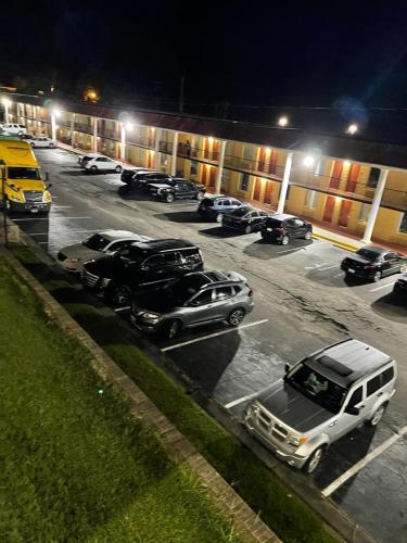 a parking lot with cars parked in front of a building at Orangeburg inn & Suites in Orangeburg