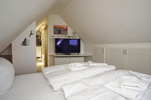 two white beds in a room with a tv at moderne FeWo Nr 5 mit Balkon, Sauna im Haus, Garten - Ferienwohnungen am Wald in Klein Gelm
