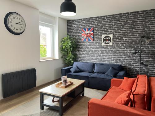 - un salon avec un canapé bleu et un mur en briques dans l'établissement Le Victor Hugo, à Calais