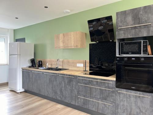 une cuisine avec un évier et un micro-ondes dans l'établissement Le Victor Hugo, à Calais