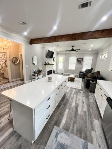 Una cocina grande con encimera blanca y una sala de estar. en Walk or Bike Ride to beach and Centrally located, en Gulfport