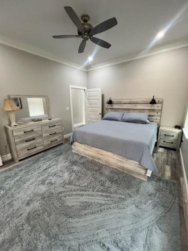 Un dormitorio con una cama y un ventilador de techo. en Walk or Bike Ride to beach and Centrally located, en Gulfport